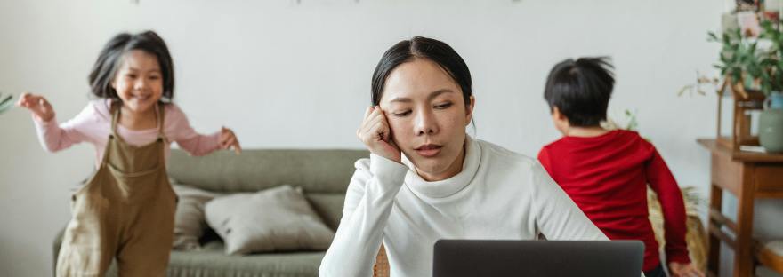 busy woman at keyboard preparing for an interview with children playing in background
